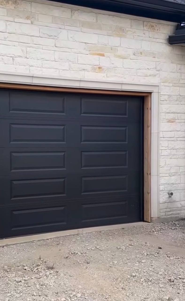 Garage door before: black door with raw cedar trim