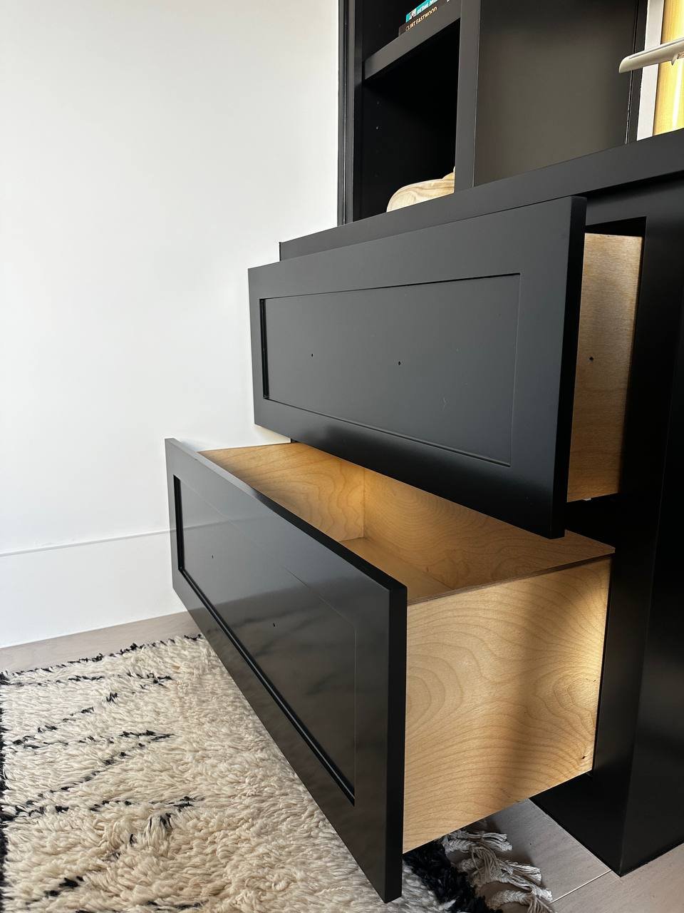 Black drawer fronts with a smooth finish on birch plywood drawers